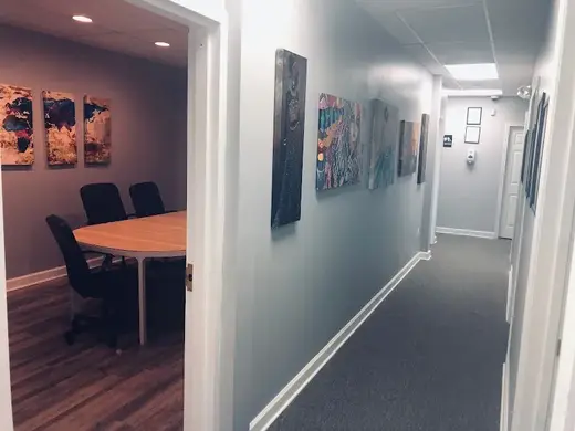 Art-lined hallway leading to meeting room at Veni Vidi Vici Treatment Services, a detox center in Baltimore.