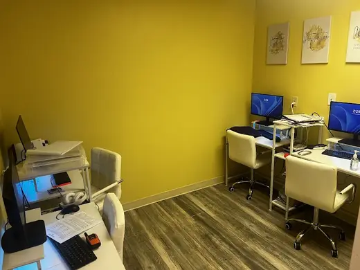 Bright workspace with computers at Created for Greater Health Systems, a sober living home in Baltimore.