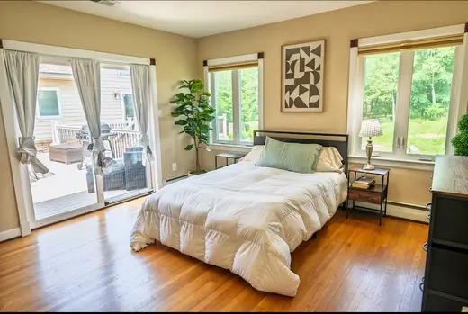 Cozy bedroom with large windows at Bay Homes Sober Living, a sober living home in Baltimore.